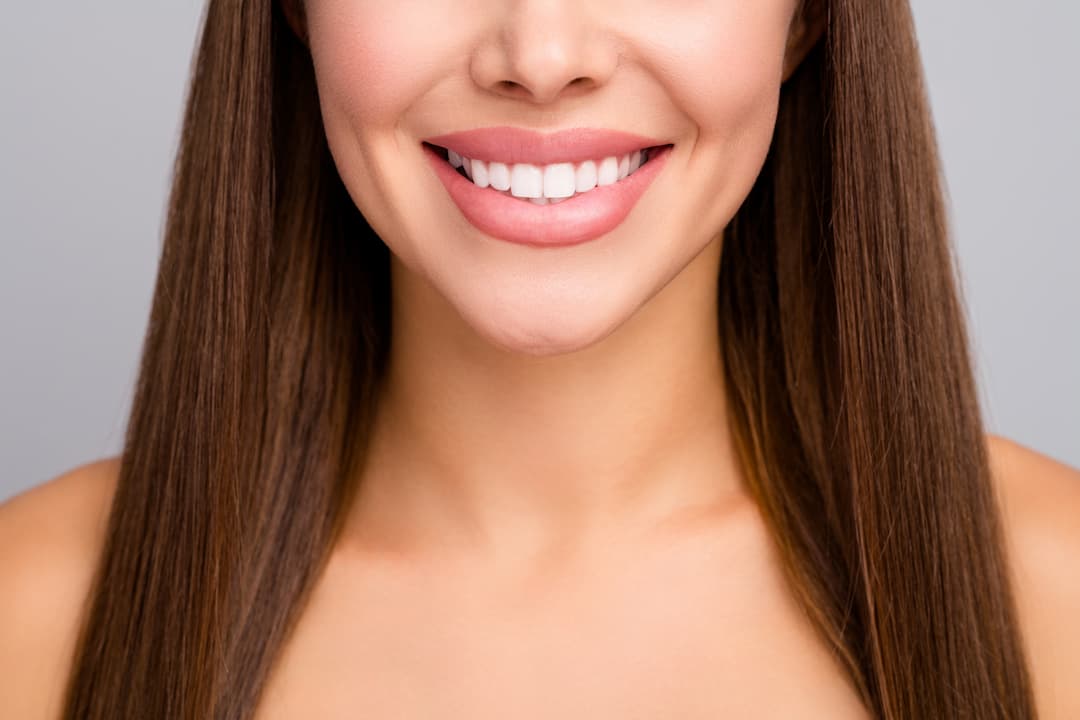Woman With Brown Hair And Big, Straight White Smile
